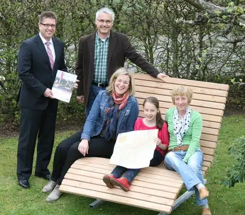 Ein Gewinn für alle – (1. v.l.) Andreas Wehmeier (Volksbank) und Ulrike Becker (3. v.l., Rothaarsteigverein) gratulieren Lena Eickelmann und ihren Eltern zum Original Rothaarsteig-Waldsofa 