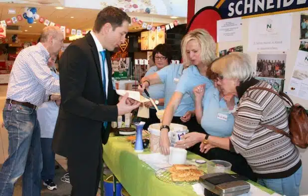 Auch Bürgermeister Bernhard Baumann (Mitte) und Johannes Schneider (links) von der Gemeindeverwaltung ließen es sich nicht nehmen zum fünften Geburtstag von Hand in Hand Neunkirchen zu gratulieren und eine der leckeren Waffeln zu kosten (Foto: Gemeinde Neunkirchen).