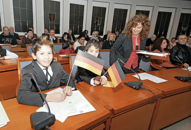 Zum ersten Mal veranstaltete der Kreis Soest am 1. Dezember 2009 eine Einbürgerungsfeier. Diese beiden jungen Neubürger zeigten sofort „Flagge“, als sie die Urkunde erhalten hatten (Foto: Müschenborn/Kreis Soest).