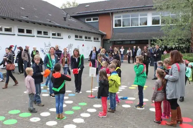 Lust aufs Spielen machen die neuen Spielfelder auf dem Schulhof der Rudersdorfer Grundschule. Schulleiterin Felicitas Arndt und Wilnsdorfs Bürgermeisterin Christa Schuppler (Bildmitte)  haben die neuen Bewegungsspiele unter den Augen von Schulsozialarbeiterin Lisa Buchmann (r.) direkt ausprobiert (Foto: Gemeinde Wilnsdorf).