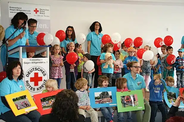 Die DRK-Kindergartenkinder aus der Mozartstraße zeigen Bilder von der Baustelle des U3-Anbaus und eröffneten die festliche Einweihung mit Liedern (Foto: DRK-Kreisverband Siegen-Wittgenstein e.V.).