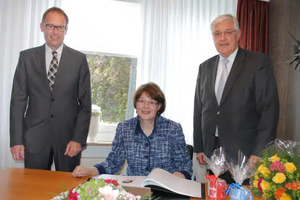 Susanne Veltins, Inhaberin der Brauerei C. & A. Veltins, trug sich im Beisein von Bürgermeister Uli Hess (r.) und Stadtkämmerer Jürgen Bartholme ins Ehrenbuch der Stadt Meschede ein (Foto: Stadt Meschede).