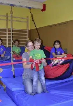 Joris durchschnitt im Namen der „Kleinen Strolche“ die symbolische Schleife bei der Übergabe der Schaukelanlage. Unterstützt wurde er dabei von seiner Mutter Tanja Schmack (Foto: Stadt Iserlohn).