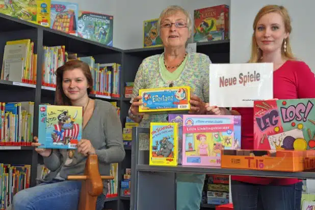 Die Mitarbeiterinnen der Stadtbücherei (v.l.), Ricarda Grieß, Barbara Bürger und Darja Lerch, präsentieren einen Teil der neuen Spieleauswahl (Foto: Stadt Lippstadt).