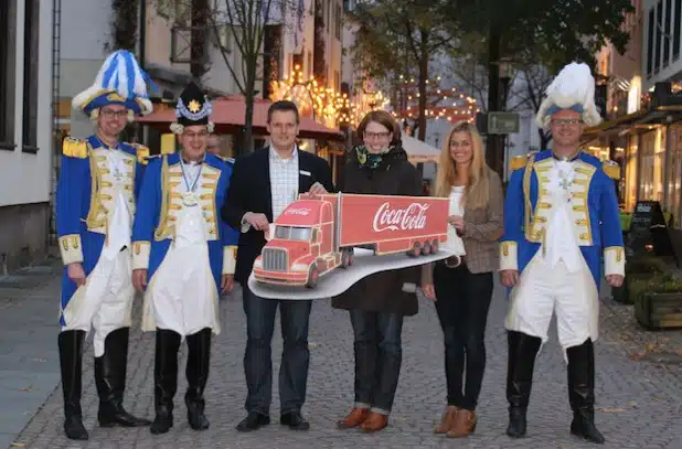 Christoph Höffer (l.), Ralf König (2. v.l.) und Frank Brettschneider (r.) von der Prinzengarde Attendorn freuen sich mit Frank Burghaus (3. v.l.), Susanne Filthaut (3. v.r.) und Kristin Meyer (2. v.r.) von der Hansestadt Attendorn auf den Besuch vom Coca-Cola Weihnachtstruck am 14. Dezember 2014 (Foto: Hansestadt Attendorn).