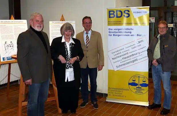 Jürgen Otto, Gabriele Franke, Hans-Peter Hasenstab und Emil Röther laden zum Besuch der Infostände über das Schiedsamt ins Hilchenbacher Rathaus ein (Foto: Stadt Hilchenbach).