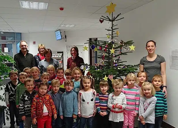 Standortleiterin Alexa Senger (2. v.l.) und ihr Mitarbeiter Jürgen Süßenbach (l.) von der AHA freuen sich sehr über den bunten Baum. Helga Braunhardt, Silke Hoppe und Janine Witt (v.l.) haben die letzte Zeit viel mit den Kindern gebastelt und sorgen gerne für weihnachtliche Stimmung (Foto: Lena Strutz/Jobcenter AHA).