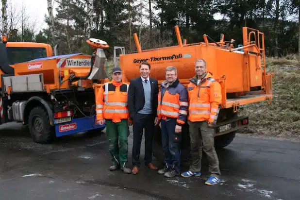 Sven Rothenpieler, Bürgermeister Bernhard Baumann, Achim Reeh und Bauhofleiter Alexander Pütz vor dem Teeranhänger, der den Bauhofmitarbeitern eine Runde heiße Fleischwurst einbringt (Foto: Gemeinde Neunkirchen).