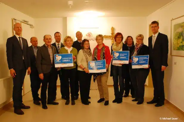 Die Volksbank Bigge-Lenne-Vorstandsmitglieder Andreas Ermecke (l.), Michael Griese (r.) und Marketingleiter Frank Segref (4. v.l.) bei der Scheckübergabe „Sparen mit Herz“ an die Hospizinitiativen im Kreis Olpe und im Hochsauerlandkreis im St. Elisabeth Hospiz in Altenhundem (Foto: Michael Sauer).