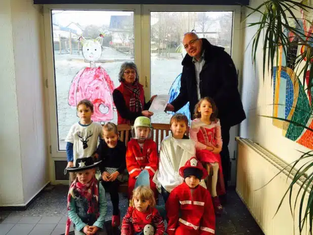 Martin Albert, Vorsitzender des Arbeitskreises Brandschutzerziehung, übergibt den Flyer zum Malwettbewerb an die Leiterin des Herdringer Kindergartens „Krähennest“, Anni Franke (Foto: Freiwillige Feuerwehr der Stadt Arnsberg).