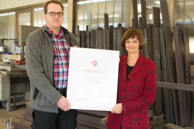 Dr. Bettina Wolf, Leiterin der Arbeitsagentur, überreicht Harald Görnig in seiner Werkstatt das Ausbildungszertifikat (Foto: Arbeitsagentur Siegen).