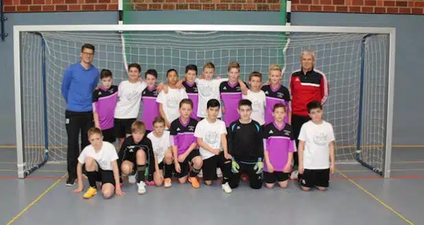 Auf dem Foto sind die Schulmannschaften des St. Ursula-Gymnasiums und der AWS vereint und mit ihren beiden Sportlehrern und Trainern Jürgen Schmitz (rechts) und Christoph Escherhaus (links) zu sehen - Foto: Agnes-Wenke-Schule.