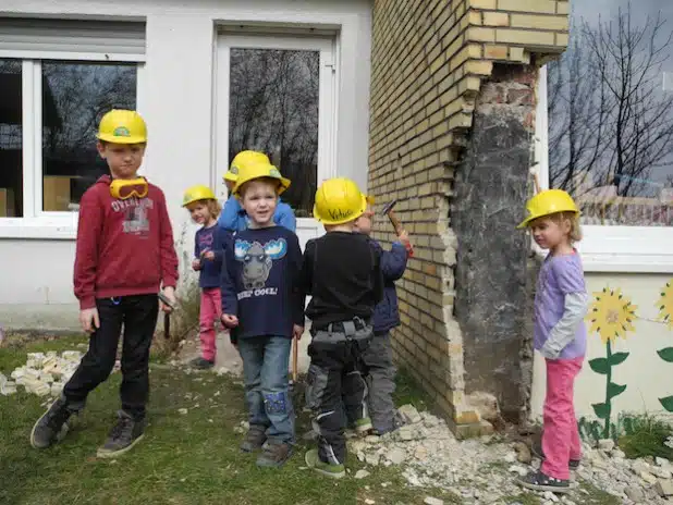 Mit Hammer und Schutzausrüstung legten die Kinder des Kindergartens Würgendorf schon los und läuteten den Abbruch des Gebäudes ein (Foto: Gemeinde Burbach).