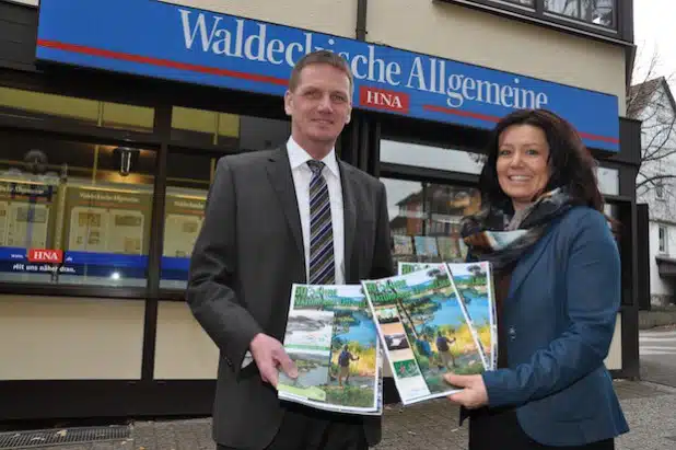 Die Anzeigenleiterin der HNA Waldeckischen Allgemeinen, Tanja Althaus, hält gemeinsam mit dem Zweckverbandsvorsteher des Naturparks Diemelsee Thomas Trachte die ersten Exemplare der Jubiläumsbeilage in den Händen (Foto: Wirtschaftsförderung Willingen).