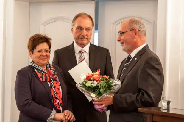 Elmar Reuter (Mitte) mit seiner Ehefrau (rechts) und Regierungspräsident Dr. Gerd Bollermann (Foto: Bezirksregierung Arnsberg).