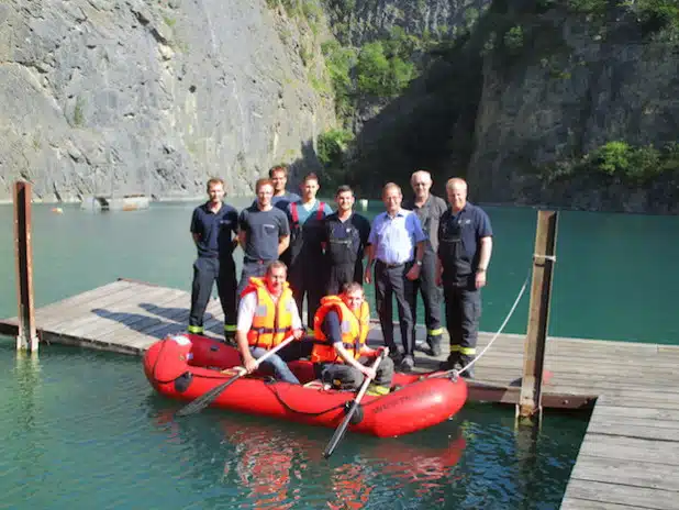 Die Feuerwehr Kallenhardt mit neuem Rettungsboot. Im Boot: DR Guido Mausbach (WESTKALK) und Feuerwehrkamerad Jens Rösner. Auf dem Steg: Die Löschgruppe der Feuerwehr Kallenhardt und Franz-Bernd Köster, WESTKALK - Foto: FW Kallenhardt/WESTKALK.