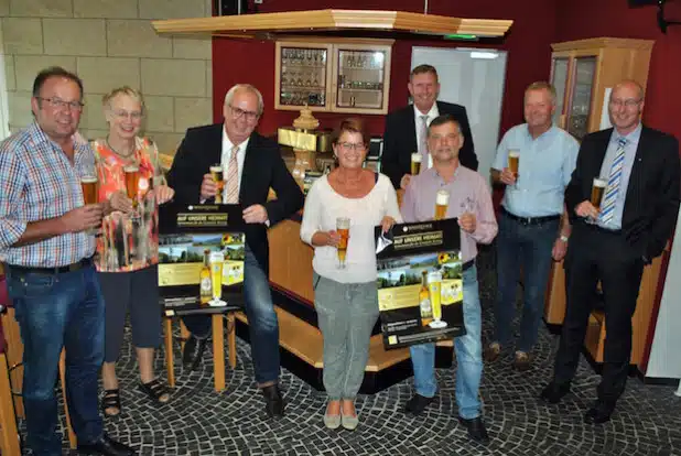 „Auf unsere Heimat“: Bestwigs Bürgermeister Ralf Péus (3.v.li.) und Manfred Nieder (4.v.re.), Gebietsverkaufsleiter der Warsteiner Brauerei, stellten mit den Ortsvorstehern (v.li.) Ulrich Bathen (Heringhausen), Adelheid Bamfaste (Velmede-Bestwig), Ulrike Mikitta (Andreasberg), Paul Schüttler (Ramsbeck), Manfred Ramspott (Ostwig) und Markus Sommer (Nuttlar) die Aktion vor (Foto: Gemeinde Bestwig).