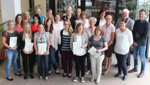 Gruppenbild mit Mann im Kreishaus-Foyer: 23 neue Grundschullehrerinnen und-lehrer haben jetzt von Schulrat Volker Reichel (2.v.r.) und Jens Sziburies (r.) ihre Ernennungsurkunden bzw. Anstellungsverträge erhalten. - Quelle: Stadt Kreis Siegen-Wittgenstein