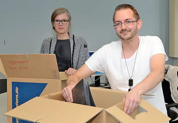 Die Mitarbeiterinnen und Mitarbeiter der Lippstädter Kfz-Zulassungsstelle, hier Larissa Schindler und Christian Bierfreund, organisieren vom 14. bis 18. September den Umzug zur Mastholter Straße und packen Umzugskarton. Die Wiedereröffnung erfolgt am 21. September 2015 (Foto: Wilhelm Müschenborn/Kreis Soest).