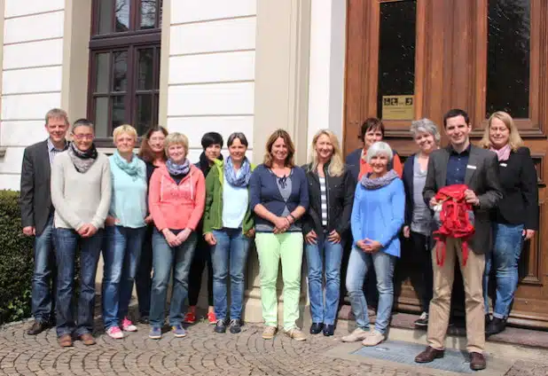 Attendorns Bürgermeister Christian Pospischil (2.v.r.), sowie Christiane Plugge (r.), Marion Terschlüsen (4.v.l.) und Christof Schneider (l.) von der Hansestadt Attendorn sowie Heike Arns (3.v.r.), Mitinitiatorin des Projektes, freuen sich  mit den Attendorner Erzieherinnen über den „Begrüßungsrucksack“ (Foto: Hansestadt Attendorn).