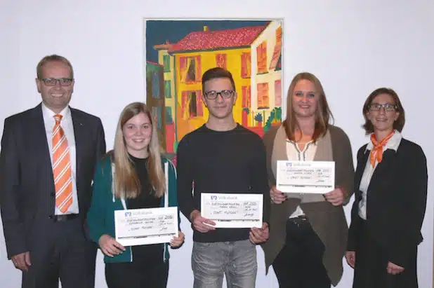 Regionalmarktleiter Ralf Wildraut (links) und Marketingleiterin Silke Niederschlag (rechts) übergaben den drei Gewinnern einen symbolischen Scheck von jeweils 250 Euro (Foto: Volksbank Olpe-Wenden-Drolshagen eG).