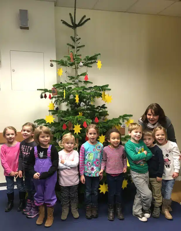 Stolz präsentieren die Kinder des Familienzentrums Werl-Nord mit ihrer Erzieherin Meike Laugsch den geschmückten Tannenbaum im Jobcenter Arbeit Hellweg Aktiv (AHA) - Foto: AHA.