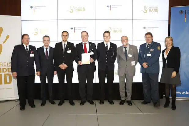 Preisverleihung in Berlin (von links): Jörg Koschig, Dr. Thomas de Maizière (Bundesinnenminister), Toni Eichler, Ulf Richter, Stephan Vogt, Prof. Dr. Gebhard Rusch , Reiner Senner (Ortsbeauftragter THW Siegen) und Moderatorin Anne Gesthuysen - Foto: Universität Siegen