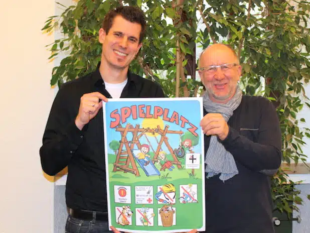 Markus Hohmann (li.) und Karl Schulte von der Hansestadt Attendorn präsentieren das neue Spielplatzschild und hoffen auf eine rege Beteiligung an der Planungswerkstatt für den Spielplatz Dortmunder Straße am 18. Februar (Foto: Hansestadt Attendorn).