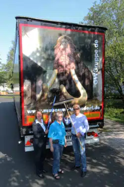 Bürgermeisterin Christa Schuppler, Museumsleiterin Dr. Corinna Nauck und Spediteur Guido Wertebach polieren „Willy“ auf Hochglanz, bevor er über die Straßen rollt - Quelle: Gemeinde Wilnsdorf